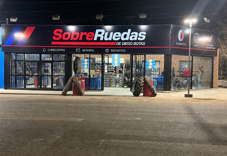 Frente iluminado del local de Sobre Ruedas de Diego Botas de noche
