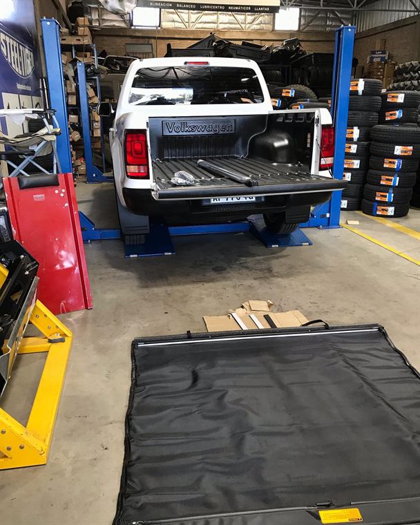 Colocación de cobertor de lona en la caja de una camioneta