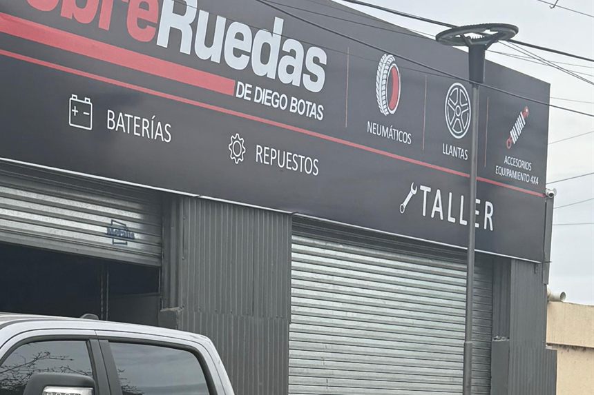 Cartel del local de Sobre Ruedas con los servicios de lubricentro, baterías y repuestos